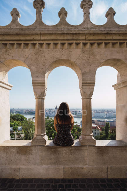 Femme assise sur une clôture en marbre à colonnes à Budapest — Photo de stock