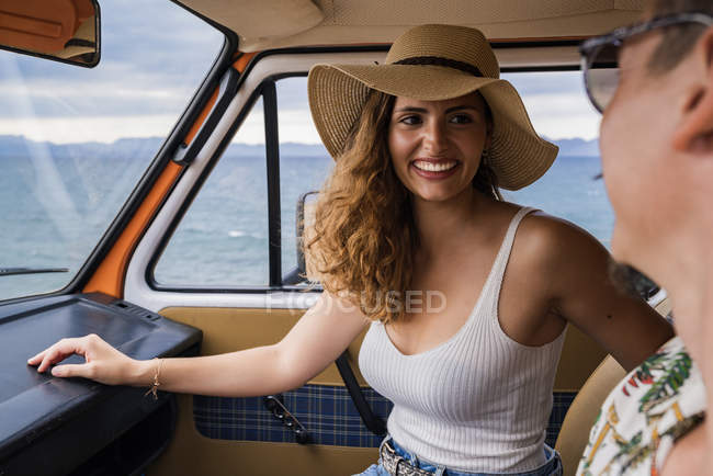 Active smiling woman and man in sunglasses looking at each other in car — Stock Photo