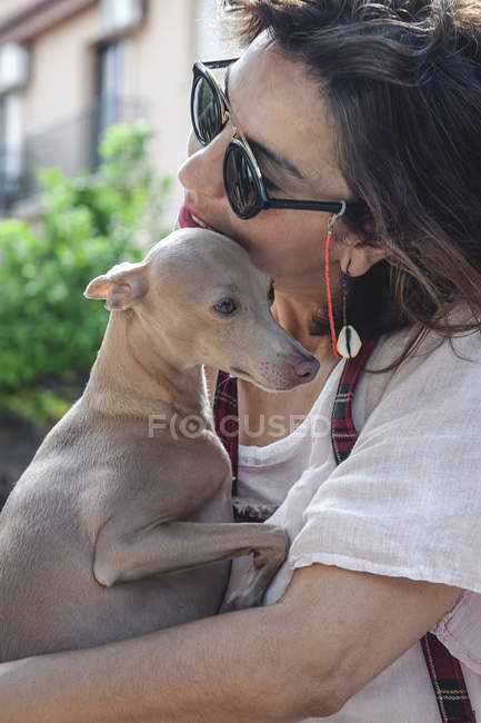 Сторона зору щасливої жінки, яка обіймає собаку, відпочиваючи разом у Марбельї. — стокове фото
