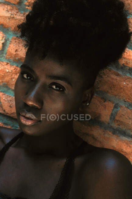 Чорна жінка спирається на стіну — стокове фото
