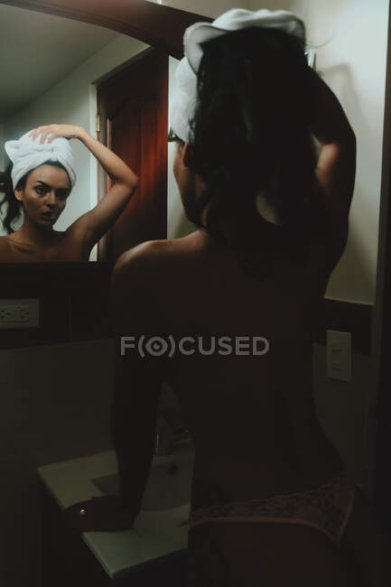 Спокойная чувственная голая женщина против зеркала в ванной комнате — стоковое фото