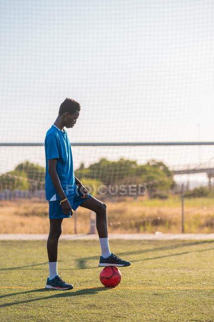 Jogador de futebol preto com bola de pé no estádio — Fotografia de Stock