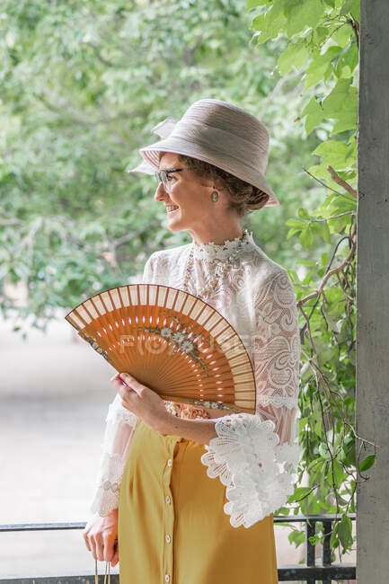 Femme avec ventilateur rétro dans le parc — Photo de stock