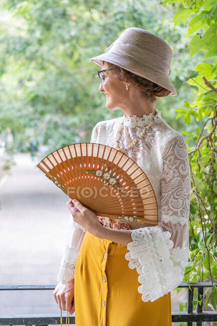 Femme avec ventilateur rétro dans le parc — Photo de stock