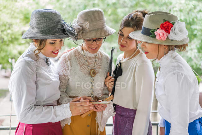Senhoras vintage usando smartphone no jardim — Fotografia de Stock