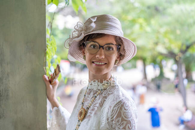Senhora sorridente em chapéu vintage no jardim — Fotografia de Stock