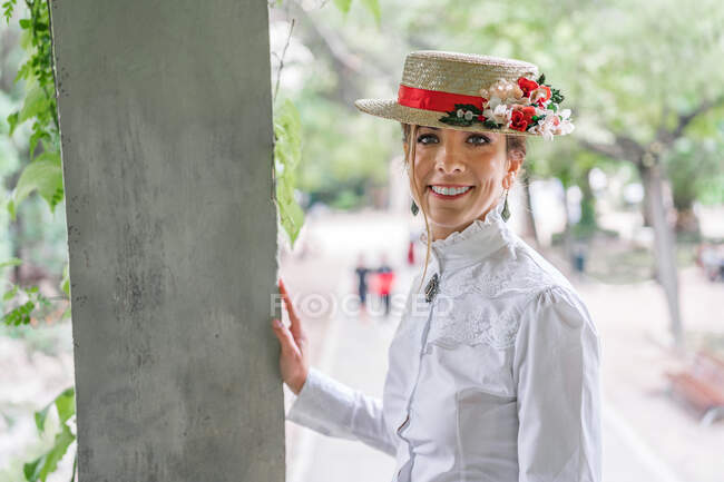 Smiling lady in vintage hat in garden — Stock Photo