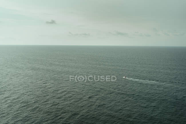 Aerial view of luxury yacht on dark water ocean and cloudy sky — Stock Photo