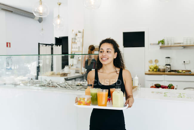 Cheerful waitress serving healthy drinks for friends — Stock Photo