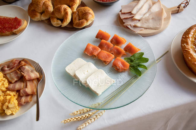 De cima de belo prato de salmão de morsel com hortelã e queijo brinsen decorado pedaço de trigo no ambiente de mesa para o pequeno-almoço — Fotografia de Stock