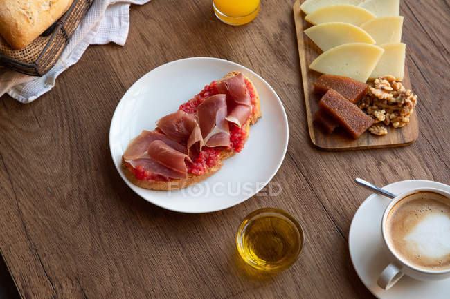 From above of tasty spanish toast with tomato and bacon for breakfast on wooden table — Stock Photo