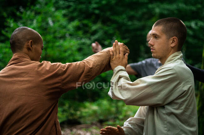 Senior homme formant étudiant en arts martiaux dans la forêt — Photo de stock