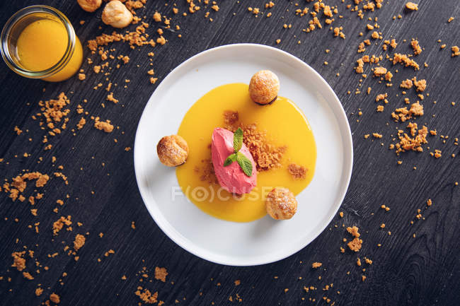 Sorvete de framboesa com laranja curável, chocolate e bolos folhados em prato — Fotografia de Stock