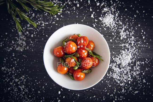 Tomates cereja frescos refogados com espargos verdes e alecrim — Fotografia de Stock