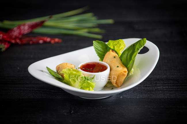 Вьетнамские роллы со сладким чили на стеклянной тарелке — стоковое фото
