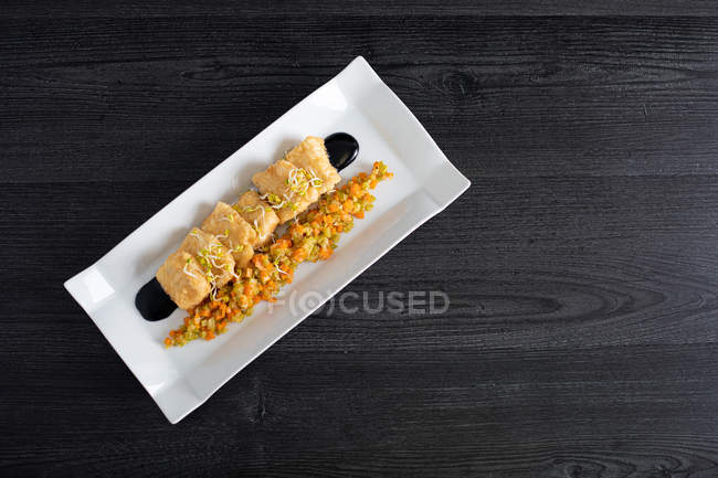 Meat breaded with matignon in white rectangular plate — Stock Photo