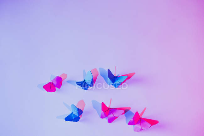 Rosa und blaue Schmetterlinge an lila Wand befestigt — Stockfoto