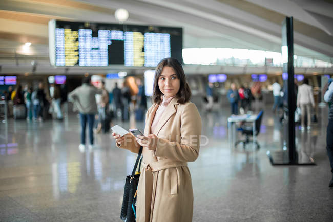 Woman using smartphone at airport — Stock Photo