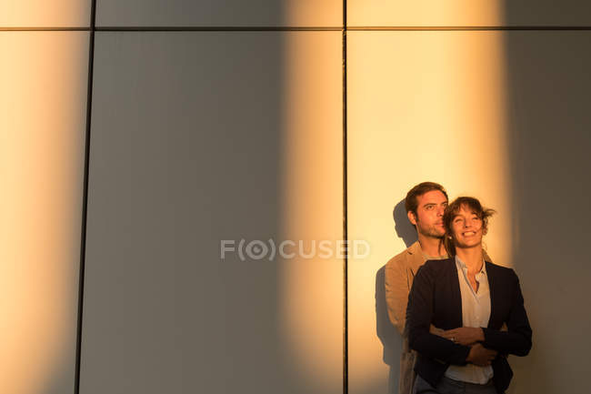 Uomo d'affari abbracciare fidanzata mentre in piedi fuori edificio moderno dopo il lavoro — Foto stock