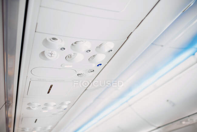 Compartimento de techo de avión blanco con diferentes botones - foto de stock