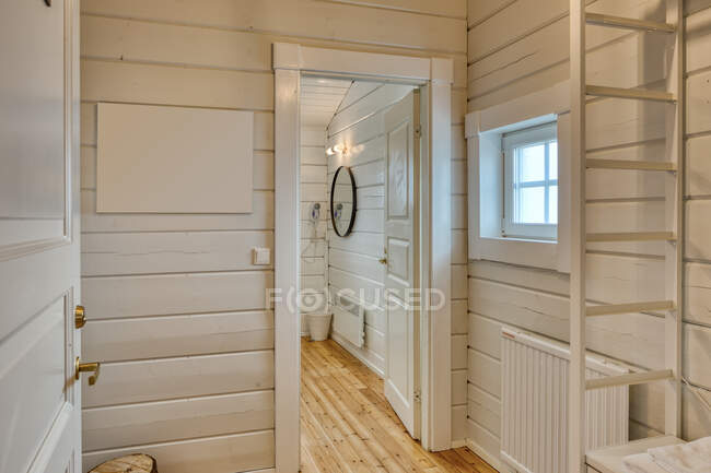 Interno minimalista di casa con pareti in legno bianco e vista del bagno in porta — Foto stock