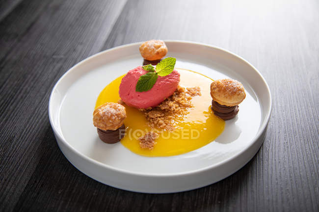 Raspberry ice cream with curable orange, chocolate and puff pastries — Stock Photo