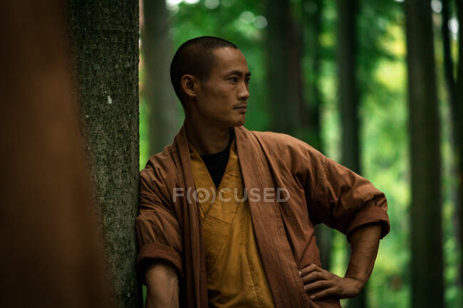 Ásia cara no marrom uniforme descansando no verde floresta — Fotografia de Stock