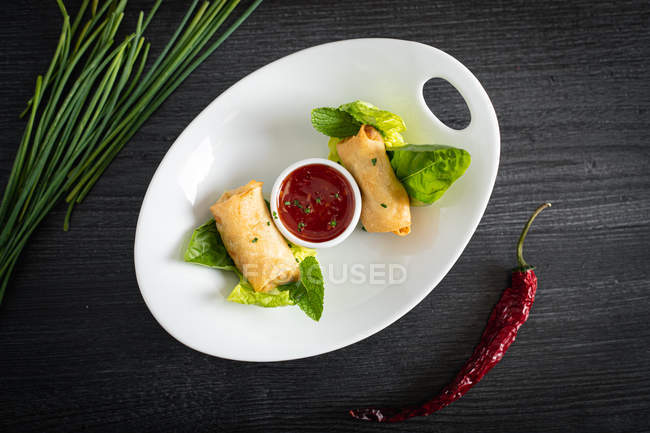 Rotoli vietnamiti con peperoncino dolce sul piatto di vetro — Foto stock