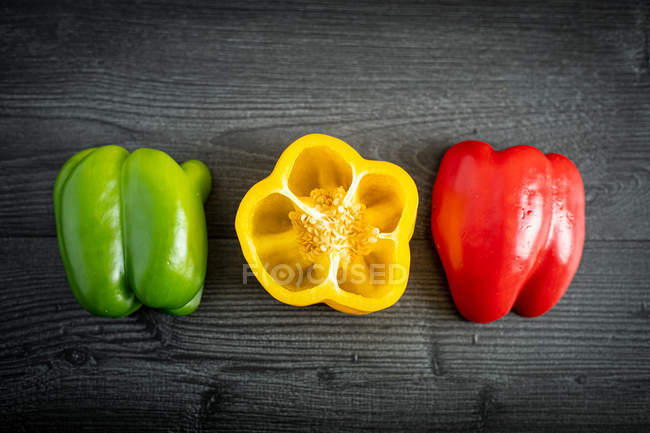 From above appetizing fresh sliced green red yellow pepper on gray surface — Stock Photo