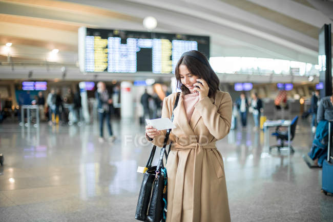 Жінка використовує смартфон в аеропорту — стокове фото