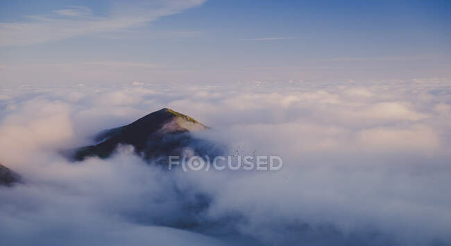 Herrlicher Blick vom Berg auf den blauen Himmel über den weißen dicken Wolken im Tal — Stockfoto