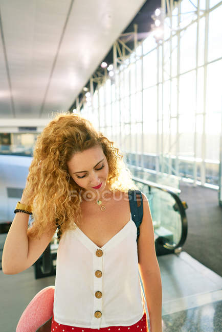 Mulher encaracolado com mochila andando no corredor do aeroporto leve no Texas — Fotografia de Stock