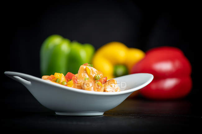 Brilhante colorido apetitoso Marmitako dashi em tigela branca no fundo com pimentas amarelas vermelhas — Fotografia de Stock