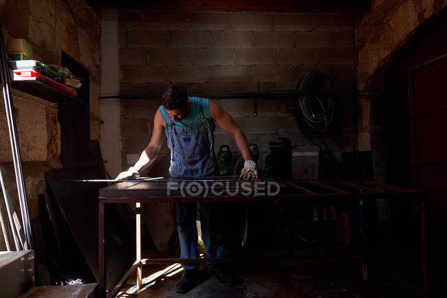 Handwerker mittleren Alters in Schutzhandschuhen, die bei der Arbeit in der Werkstatt Blech markieren — Stockfoto