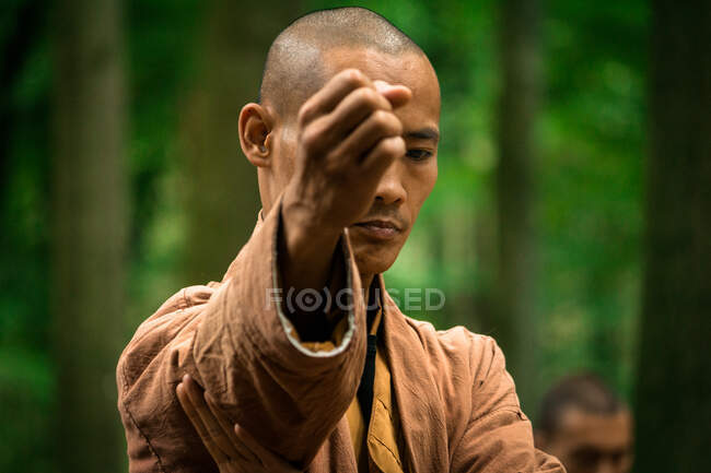 Ethnic man practicing martial arts in forest — Stock Photo
