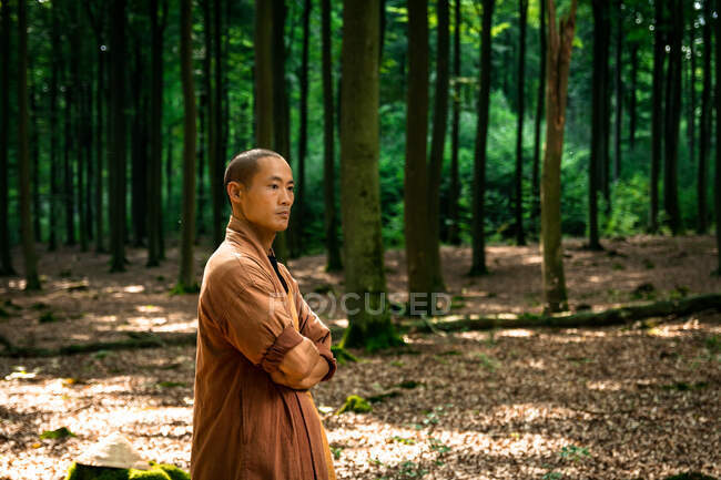 Asiatico ragazzo in marrone uniforme riposo in verde foresta — Foto stock