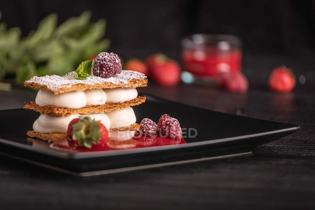 Diphlomate crema e strudel di frutta rossa in elegante piatto nero — Foto stock