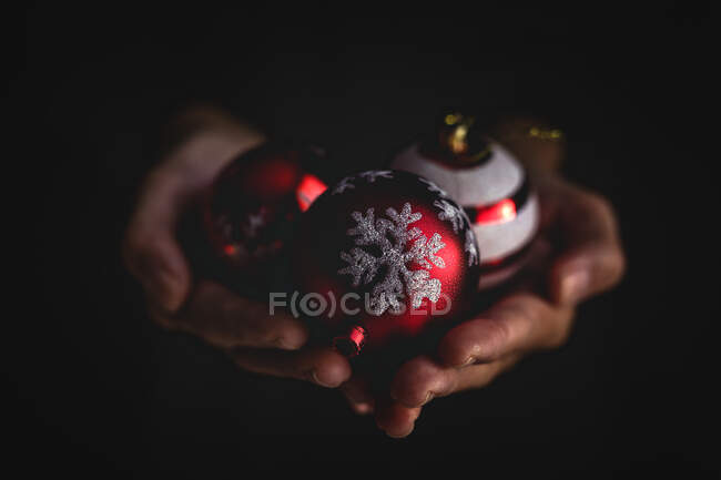 Crop person showing Christmas baubles — Stock Photo