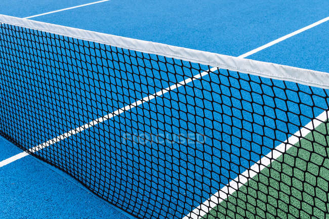 Detalhe da quadra de tênis ao ar livre azul e verde com rede preta . — Fotografia de Stock