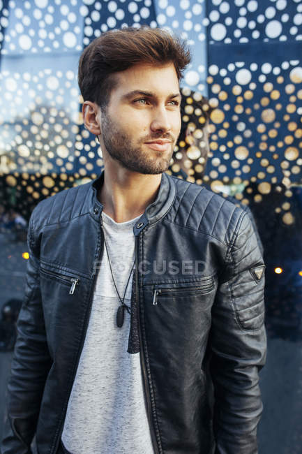 Confident fashionable male in casual stylish outfit leaning on modern  glasses wall and looking away — caucasian, gentleman - Stock Photo |  #317507704