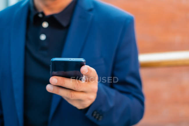Empresário sênior em casaco azul usando smartphone — Fotografia de Stock