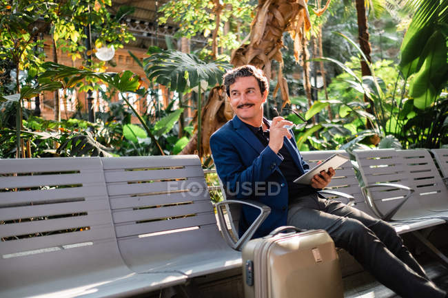 Aged handsome man using digital tablet outdoors — Stock Photo