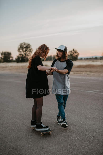 Ridere ragazzo adolescente e ragazza imparare a pattinare divertirsi sulla strada — Foto stock