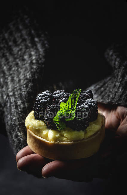 Unrecognizable person holding homemade small cake with blackberries and delicious cream of vanilla and mint — Stock Photo