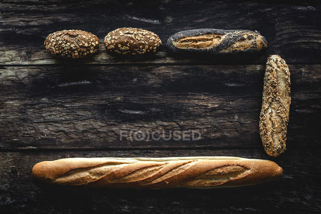 Flat lay de ouro sortimento pão caseiro no fundo de madeira escura — Fotografia de Stock