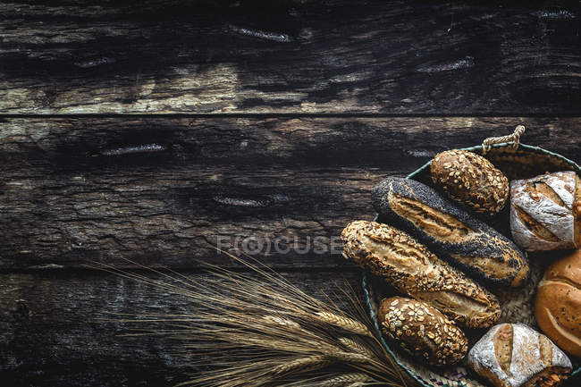 Flat lay of Gold assortment homemade bread on dark wooden background — Stock Photo