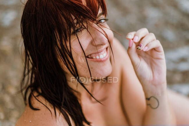Donna nuda seduta vicino onde del mare — Foto stock