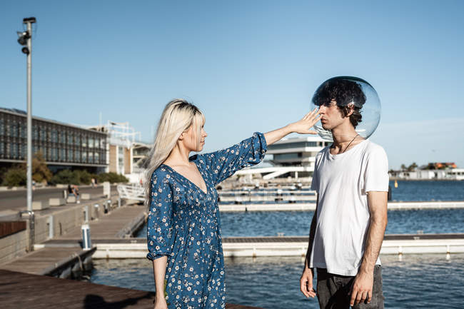 Attraktive blonde Frau berührt transparentes rundes Aquarium auf dem Kopf des Mannes — Stockfoto