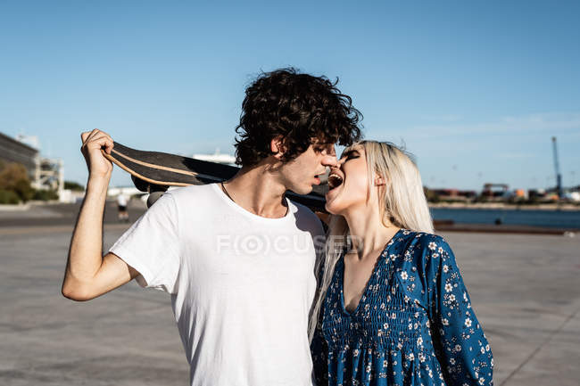 Attractive young stylist couple embracing and kissing each other on the street — Stock Photo