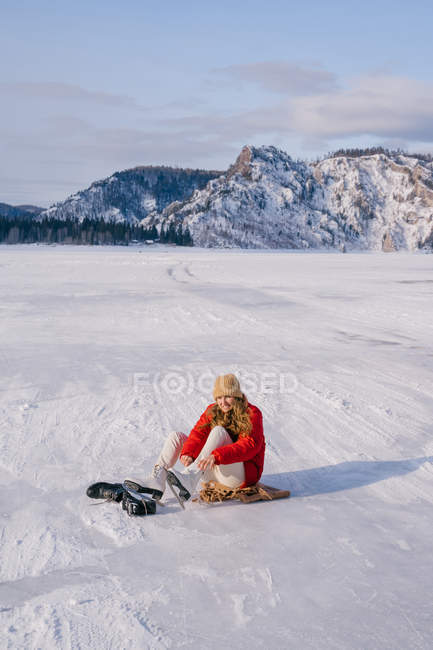 Жінка сидить на снігу і змінює чоботи — стокове фото